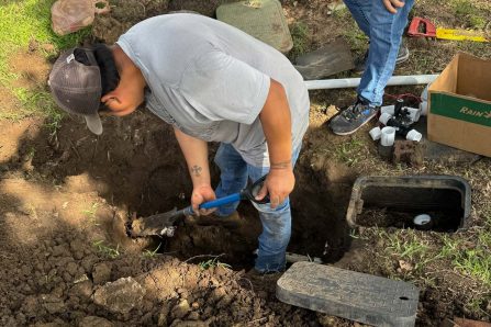 Sprinkler repair technician servicing a residential irrigation system